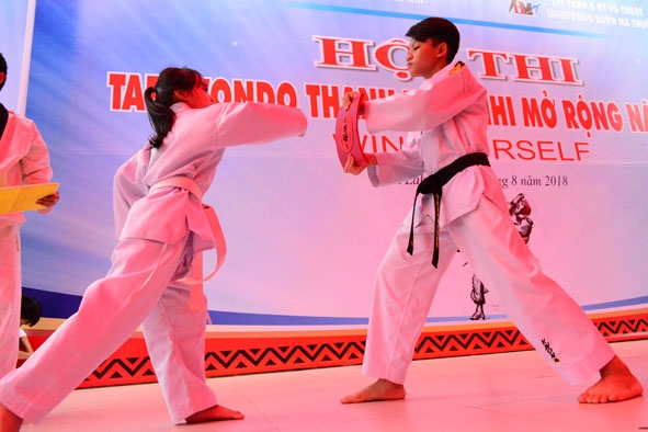 Các võ sĩ biểu diễn công phá tại Hội thi karatedo thanh thiếu nhi mở rộng năm 2018.