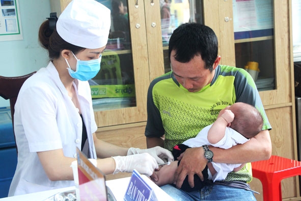 Y sỹ Trạm Y tế phường Khánh Xuân tiêm phòng cho trẻ em tại địa bàn phường.