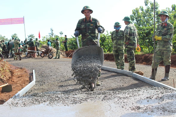 Cán bộ, chiến sĩ lực lượng vũ trang tỉnh giúp dân làm đường giao thông nông thôn.
