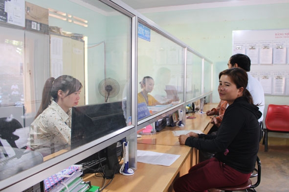 Cán bộ Bộ phận tiếp nhận và trả kết quả xã Pơng Drang (huyện Krông Búk) giải quyết hồ sơ cho người dân. 