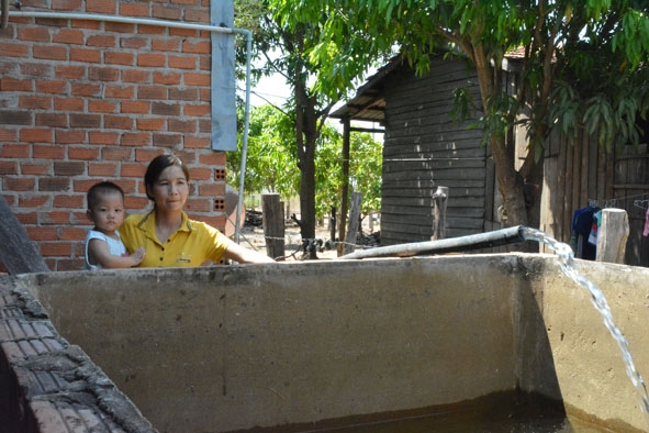 Chị Trương Thị Thúy Tình (xã Ia Lốp, huyện Ea Súp) đang bơm nước dự trữ vào bể.