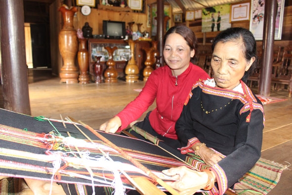 Bà H’Prak Niê ở buôn Mùi 2, xã Cư Né hướng dẫn cách dệt thổ cẩm cho em gái.