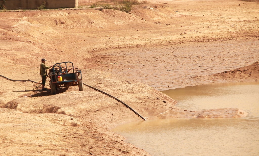 Người dân đặt máy trong lòng hồ thôn 5 (xã Cư Êwi) để bơm nước tưới do công trình không tích đủ nước.