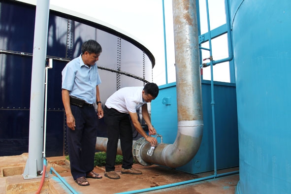 Cán bộ kỹ thuật lấy mẫu nước sau khi qua bể lọc tại Nhà máy xử lý nước Đạt Lý. 