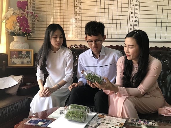 Hai em Trúc Linh - Quốc Cường cùng cô giáo hướng dẫn thực hiện dự án nghiên cứu về lan rừng. 