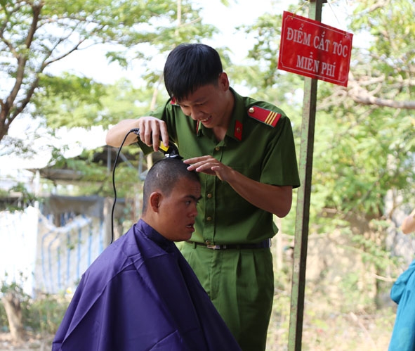 Cán bộ, chiến sĩ Công an huyện Krông Ana cắt tóc miễn phí cho người dân.
