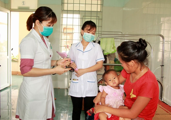 Bác sĩ Bệnh viện Đa khoa huyện Ea Súp tư vấn cho người nhà bệnh nhân cách chăm sóc trẻ bị bệnh sởi. 