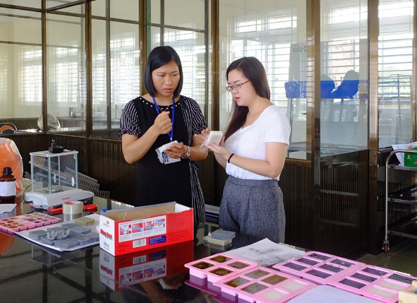 Hoàng Thị Thơm (bìa phải) cùng với giảng viên Trường Đại học Tây Nguyên nghiên cứu và thử nghiệm những dòng sản phẩm mới từ tinh dầu. 