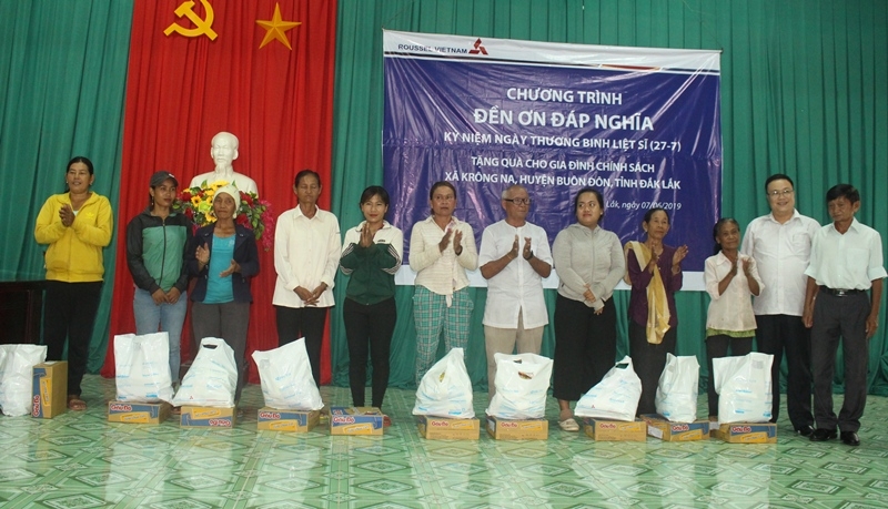 Đại diện Công ty Roussel Việt Nam (TP. Hồ Chí Minh) tặng quà cho các gia đình chính sách xã Krông Na (huyện Buôn Đôn)