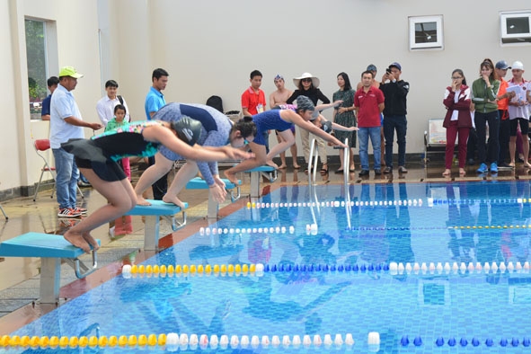 Học sinh học bơi tại Trường TH, THCS, THPT Hoàng Việt thực hành tư thế xuất phát bơi.  