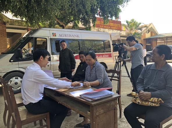 Phóng viên Đài Phát thanh - Truyền hình tỉnh đang tác nghiệp tuyên truyền về điểm giao dịch lưu động bằng ô tô chuyên dùng của Agribank tại xã Buôn Triết, huyện Lắk.  