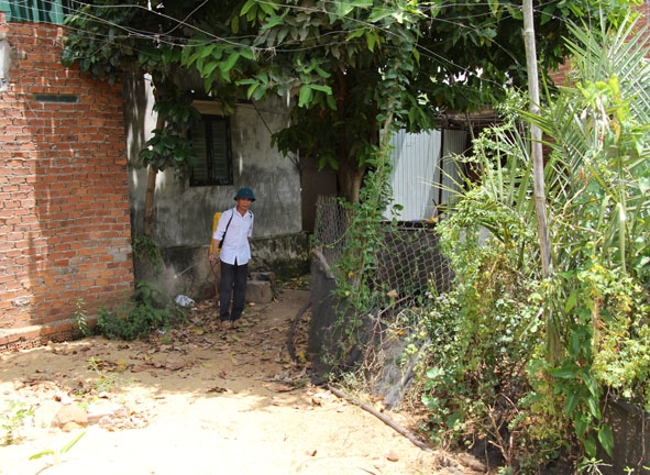 Ông Trần Ngọc Sơn phun thuốc tiêu độc, khử trùng bên ngoài trại chăn nuôi của gia đình.