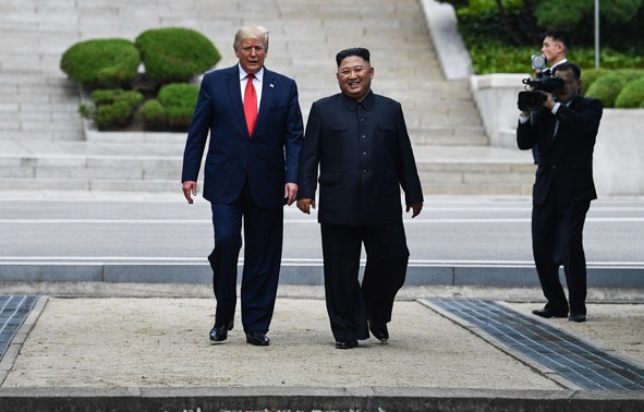 Tổng thống Mỹ Donald Trump (trái) và nhà lãnh đạo Triều Tiên Kim Jong-un (giữa) trong cuộc gặp tại Khu phi quân sự (DMZ) ở biên giới liên Triều chiều 30-6-2019. (Ảnh: AFP/TTXVN)