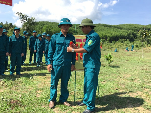 Anh Ngũ Văn Đệ (trái) được trao hoa bắn giỏi trong đợt kiểm tra bắn đạn thật  cho lực lượng dân quân tự vệ năm 2019.  