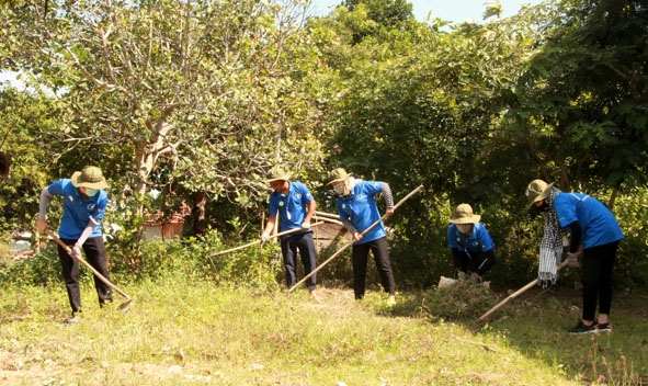 Sinh viên tình nguyện Trường Đại học Tây Nguyên dọn vệ sinh khu vực xung quanh Nhà văn hóa  cộng đồng buôn Ea Puk (xã Ea Sô, huyện Ea Kar). 