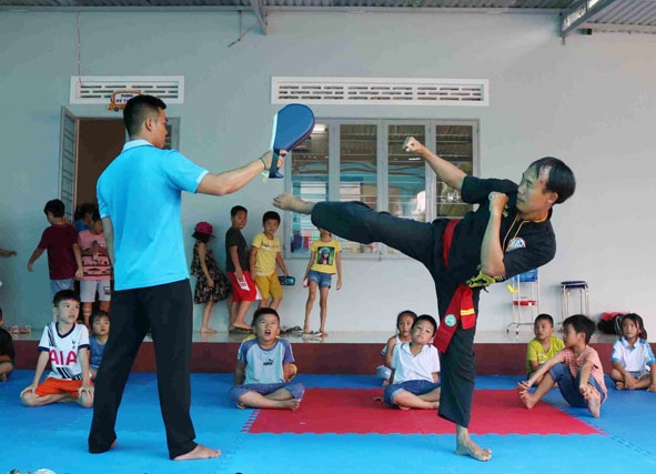 Võ sư Hoàng Minh Tuấn (bên phải) đang thị phạm cho các em võ sinh mới theo học. 