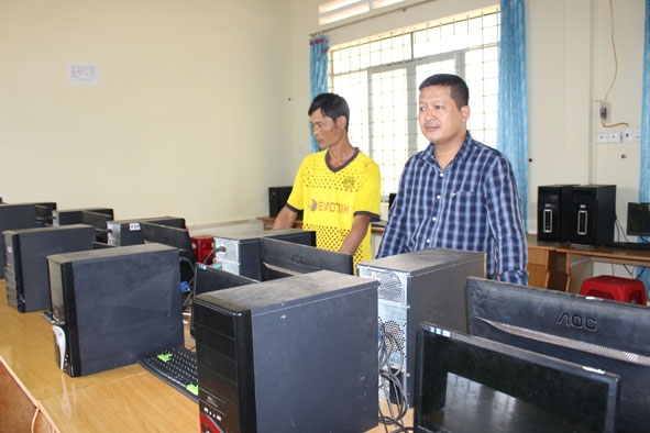 Ông Phạm Tiến Sơn (bên phải) Hiệu trưởng Trường THCS Lê Hồng Phong (xã Pơng Drang) kiểm tra phòng thực hành tin học chuẩn bị cho năm học mới 2019 – 2020. 