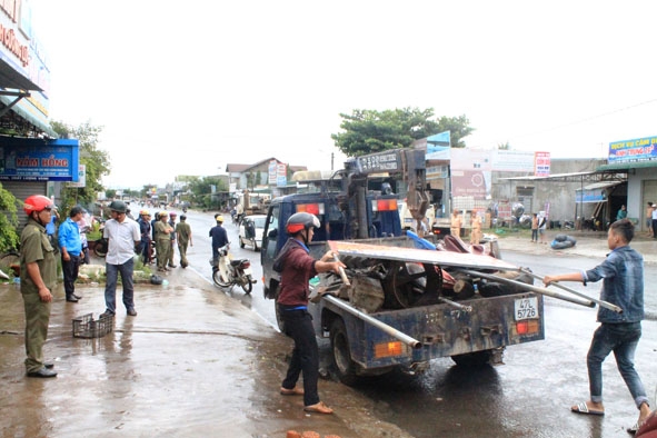 Lực lượng chức năng tiến hành cưỡng chế tang vật vi phạm hành lang an toàn đường bộ trên Quốc lộ 26  đoạn qua xã Ea Phê.