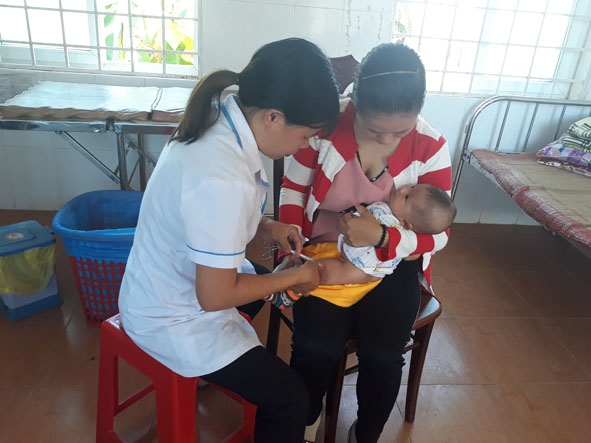 Cán bộ y tế tiêm vắc xin cho trẻ tại Trạm Y tế xã Ea M'doal. 