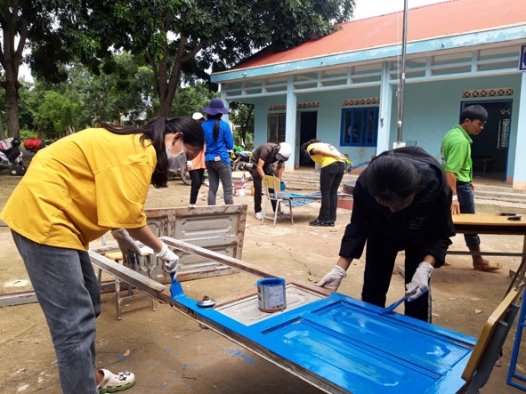 Tình nguyện viên nhóm Vòng tay yêu thương sơn cửa cho Trường Tiểu học Y Jút  (xã Krông Na, huyện Buôn Đôn). 