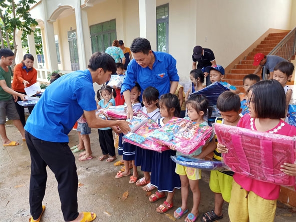 Cán bộ Đoàn huyện Ea Súp trao đồ dùng học tập tặng các em học sinh xã Ia Lốp.   