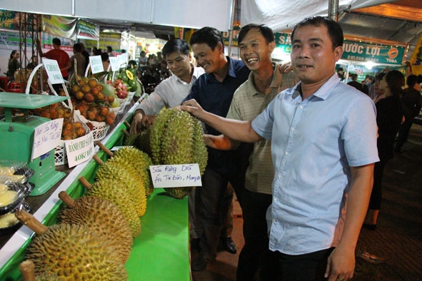 Người dân thích thú lựa chọn sầu riêng tại hội chợ. 