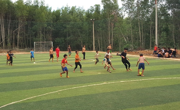 Thanh thiếu niên thôn Ea Bar chơi đá bóng trên sân cỏ nhân tạo.  