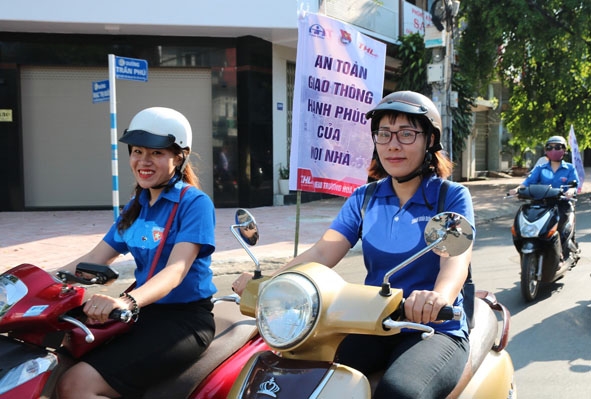 Chị Nguyễn Thị Ngọc Trinh (bìa phải) trong một lần diễu hành tuyên truyền về bảo đảm trật tự an toàn giao thông.
