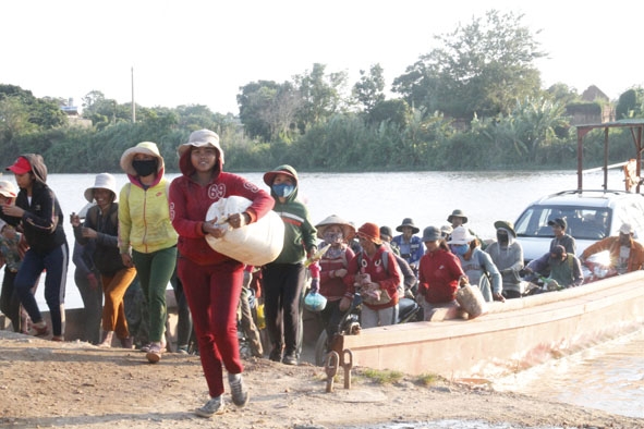 Người dân xã Ea Na trở về nhà sau một ngày lao động phía bên kia sông. 