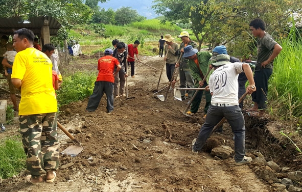 Người dân thôn Ea Uôl (xã Cư Pui) tham gia sửa chữa đường giao thông.   