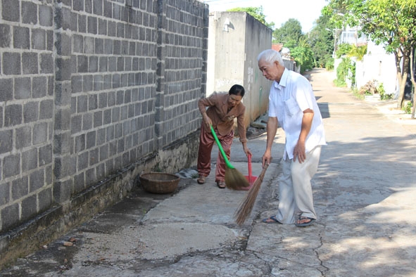 Vợ chồng ông Đinh Viết Phương quét dọn vệ sinh đường sá sạch sẽ.  