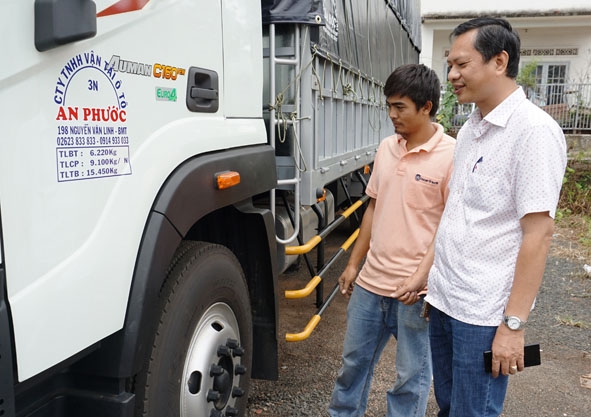 Giám đốc Công ty TNHH Vận tải ô tô An Phước Phạm Đông Thanh cùng nhân viên công ty kiểm tra số xe tải mới trang bị thêm.