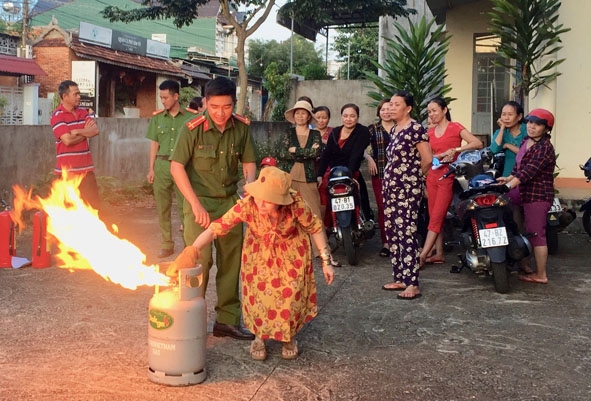 Cán bộ Đội PCCC-CNCN, (Công an huyện Cư M’gar) hướng dẫn tiểu thương chợ thị trấn Ea Pốk thực hành sử dụng các loại bình chữa cháy.