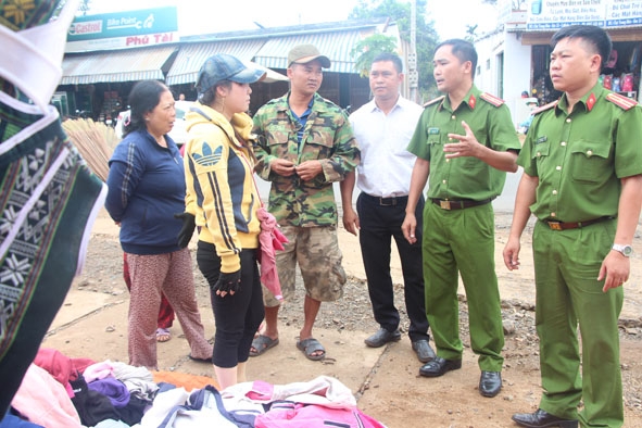 Lực lượng chức năng xã Ea Tiêu nhắc nhở hộ kinh doanh không sử dụng hành lang để buôn bán. 