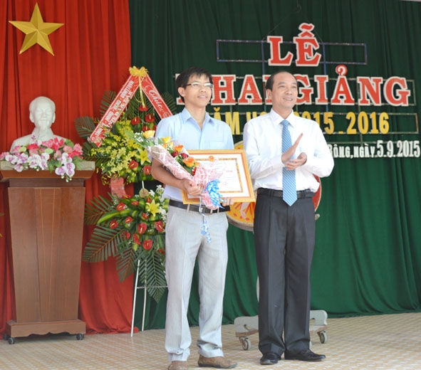 Thầy Võ  Đức Cường (bên trái) được UBND tỉnh tặng Bằng khen trong lễ khai giảng năm học 2015 - 2016. 