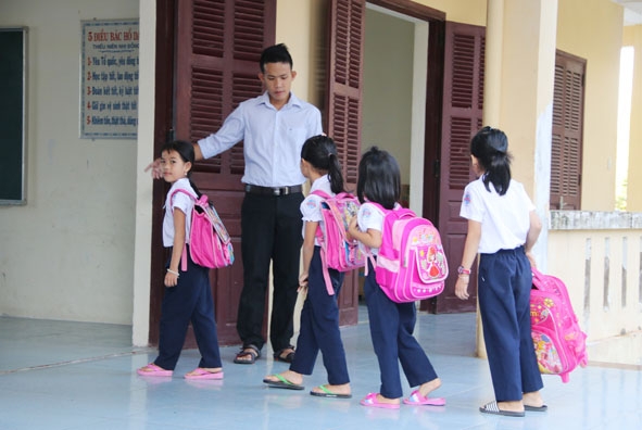 Thầy giáo Nguyễn Công Qua đón học sinh vào lớp học.