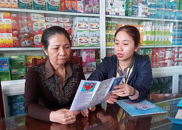 Cán bộ bưu điện huyện Cư M'gar tuyên truyền cho người dân về lợi ích khi tham gia BHXH tự nguyện.