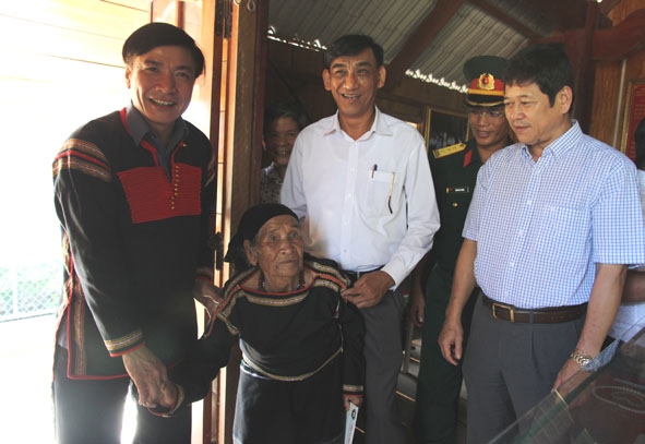 Ủy viên  Trung ương Đảng,  Bí thư Tỉnh ủy  Bùi Văn Cường  (bìa trái) đến thăm gia đình liệt sỹ  Y Ơn Niê ở xã Cư Pui (huyện Krông Bông).  Ảnh: D. Tiến