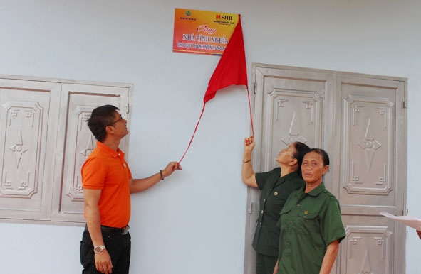 Đại diện Hội Cựu TNXP tỉnh và nhà tài trợ tặng nhà Tình nghĩa  cho bà Đàm Thị Son (bìa phải).  