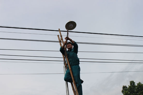 Đoàn viên, thanh niên lắp bóng điện tại một công trình “Thắp sáng đường quê”. 