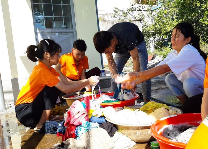 Tình nguyện viên của Đội Công tác xã hội – Thế hệ xanh – Cư Kbang giặt đồ áo cũ chuẩn bị cho cửa hàng.