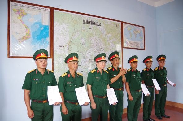 Đại úy Hoàng Văn  Thái (bìa trái) nhận quyết định thăng quân hàm.