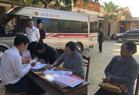  Người dân  xã Buôn Triết, huyện Lắk đến giao dịch tại điểm  giao dịch  lưu động  bằng xe ô tô chuyên dùng của Agribank.    
