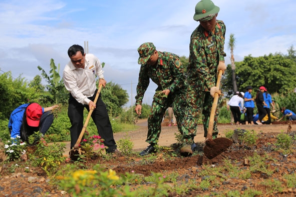 Cán bộ, chiến sĩ LLVT tỉnh giúp đỡ nhân dân xã Hòa Xuân, TP. Buôn Ma Thuột làm con đường hoa kiểu mẫu.  