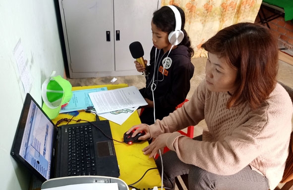 Cô Hoàng Thị Vương hướng dẫn học sinh thực hiện chương trình phát thanh Măng non.