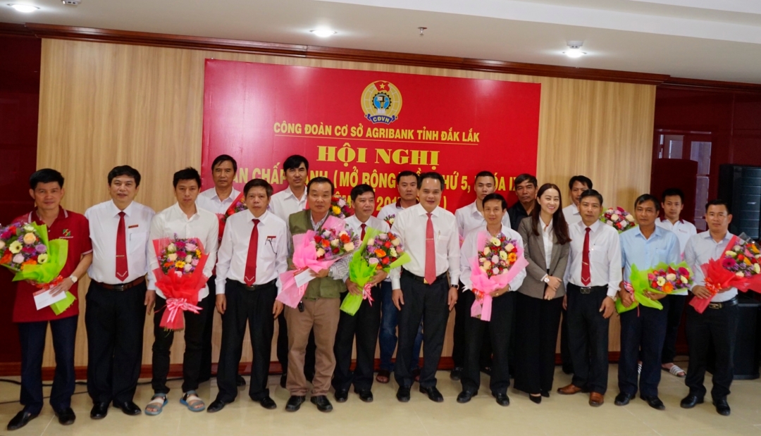 Các đồng chí đại diện lãnh đạo Đảng ủy, Ban Giám đốc, Ban thường vụ Công đoàn cơ sở Agribank tỉnh Đắk Lắk tặng quà, hoa chúc mừng và chụp ảnh lưu niệm với CBVC trong đơn vị là bộ đội xuất ngũ