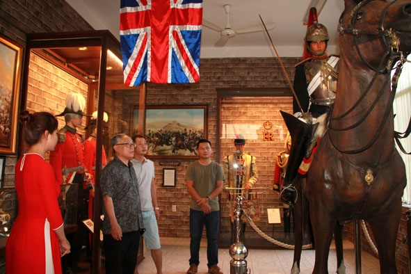 Du khách tìm hiểu trang phục của quân đội Hoàng gia Anh được trưng bày tại Bảo tàng vũ khí cổ Robert Taylor.