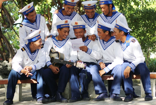 Lính trẻ hải quân đảo Sinh Tồn cùng nhau đọc thư dưới tán cây phong ba. 