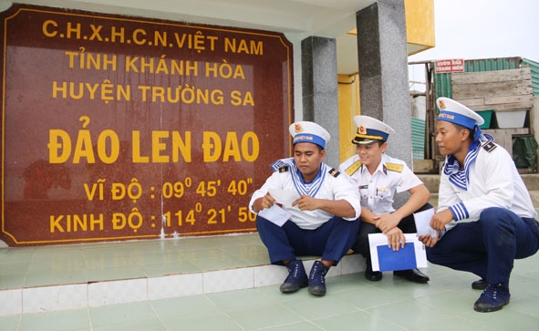 Lính trẻ hải quân đảo Len Đao cùng nhau đọc thư bên cột mốc  chủ quyền.  