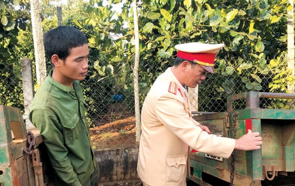 Cán bộ CSGT Công an huyện Krông Búk trực tiếp dán decal phản quang miễn phí  cho bà con ở xã Pơng Drang.